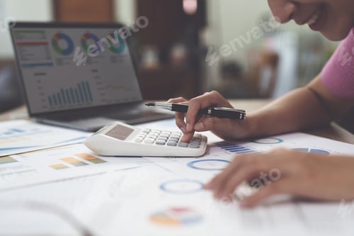 Preview: Business woman hand using calculator to calculate the company's financial results and budget