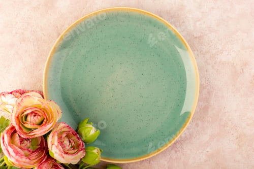 Preview: a top view green round plate along with flowers on the pink background dish food table