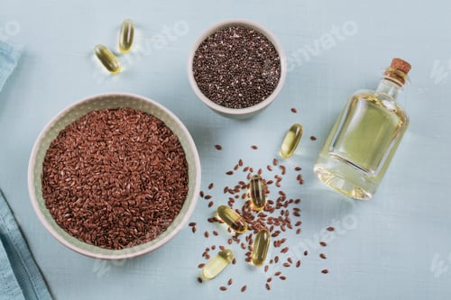 Preview: Brown flax seed or linseed and chia in small bowl and gelatin capsules