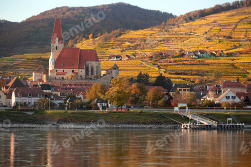 Preview: autumn view of small austrian village on a river bank