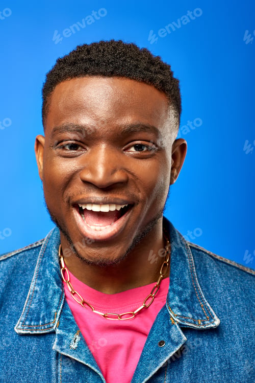 Preview: Portrait of cheerful young african american man with modern hairstyle wearing denim vest