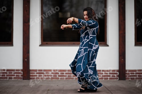Preview: Brunette indian woman in long fashionable dress posed outdoor.