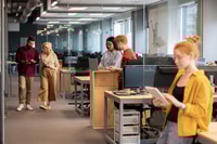 Preview: Young confident businessman with smartphone and his mature colleague talking