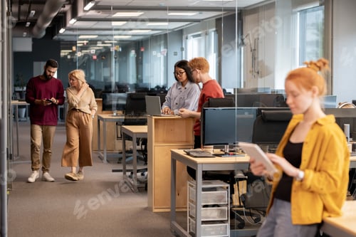 Visualização: Jovem empresário confiante com smartphone e seu colega maduro falando