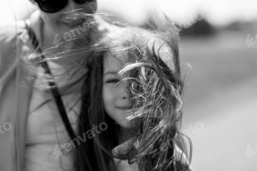 Preview: blurred black and white portrait of mother and daughter on a windy day
