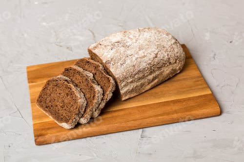 Preview: Assortment of freshly sliced baked bread with napkin on rustic table top view.