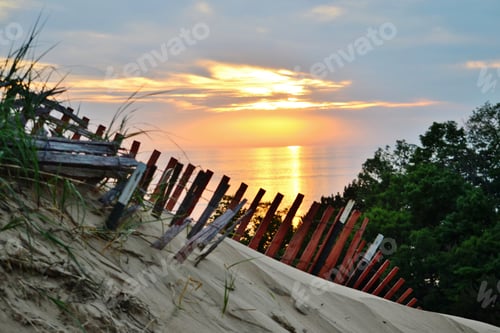 Preview: Sunset reflecting on Lake Michigan with sand dunes and wooden fence