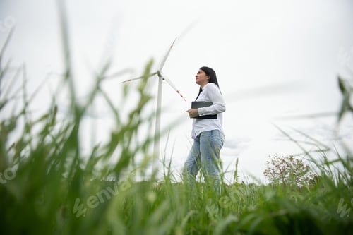 Preview: Women engineer using tablet for working on site at wind turbine farm