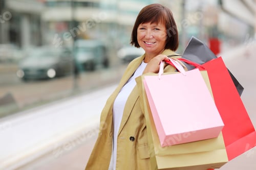 Preview: Smiling adult woman with shopping bags. Middle ages female after shopping on shopping mall backgroun