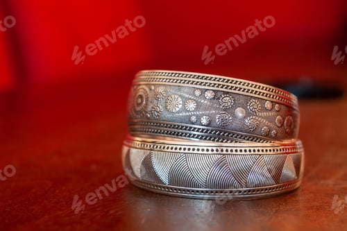 Preview: Selective focus shot of silver jewelry on red background