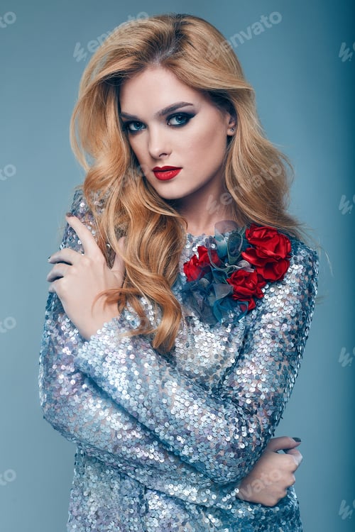 Preview: Portrait Of Beautiful Elegant Woman In Brilliant Fashionable Paillettes Dress On Blue Background In