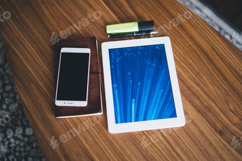 Preview: Modern tablet with smartphone and notebook on table
