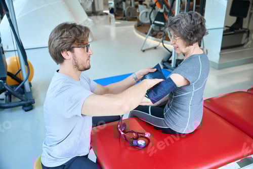 Preview: Employee of fitness clinic measures blood pressure of elderly woman