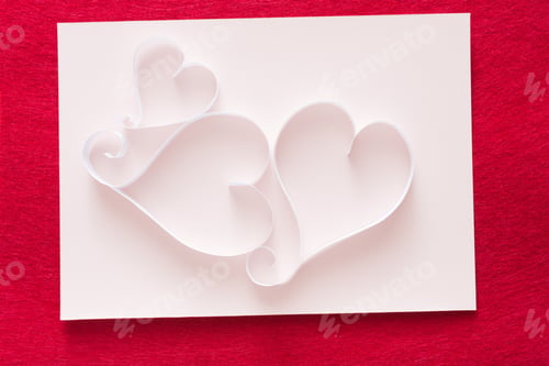 Preview: Valentine background with handmade paper heart shapes decoration on white shit of paper on red felt