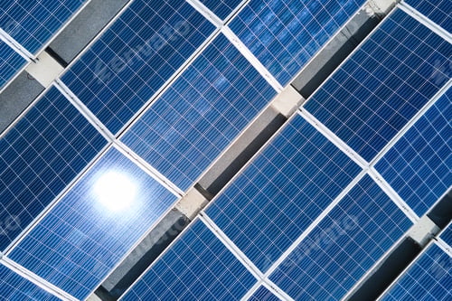Preview: Aerial view of blue photovoltaic solar panels mounted on industrial building roof for producing