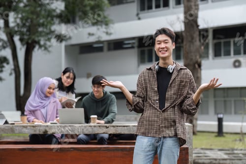 Preview: Portrait of Asian student studying in university garden. Young people spend time together, reading
