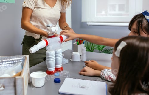 Preview: Student putting a piece in recycled toy robot made with plastic packages