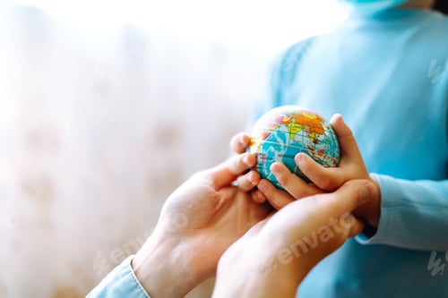 Preview: Child in protective sterile medical mask with mother holding a world globe. Save planet.