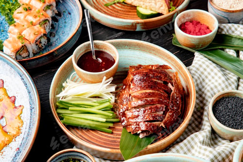 Preview: side view of traditional asian food peking duck with cucumbers and sauce on a plate