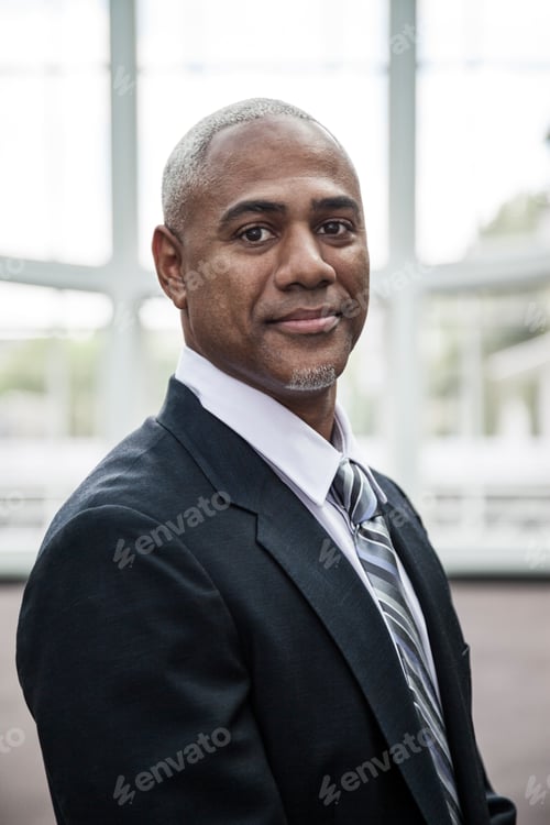 Preview: View of a black business man in a dress shirt, tie and suit coat