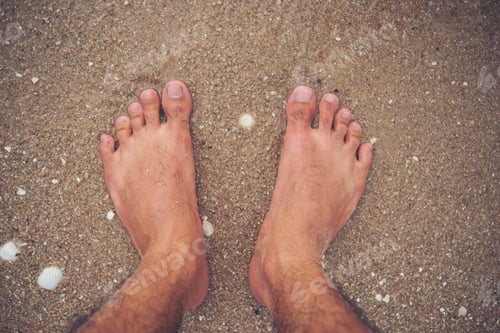 Preview: Young man feet on the beach.