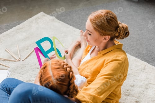 Preview: mother and daughter learning alphabet on floor at home