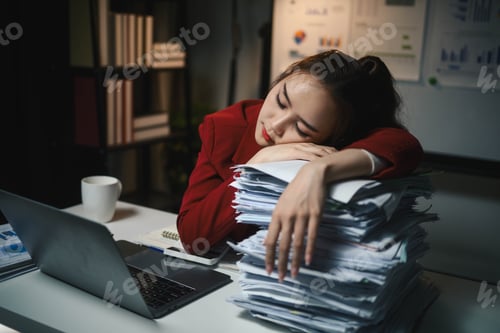 Preview: Business woman in a red jacket is sleeping on a desk with stacks of papers