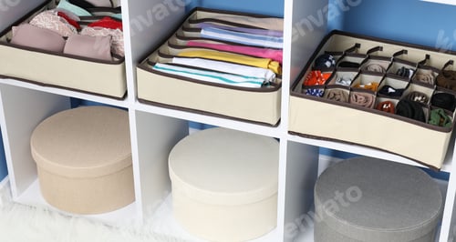 Preview: Organizers with folded clothes and underwear on shelves at home