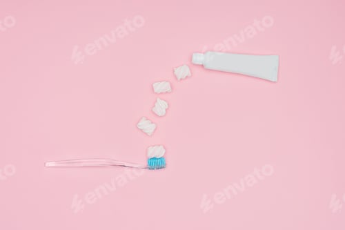 Preview: top view of marshmallows, toothbrush and toothpaste tube isolated on pink
