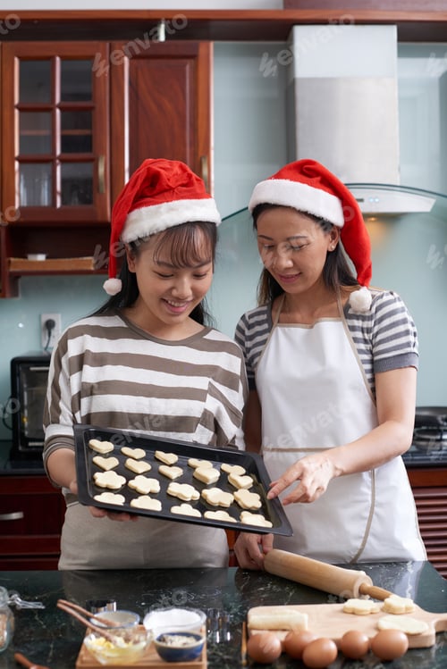 Women Baking Christmas Cookies in Kitchen with Hats