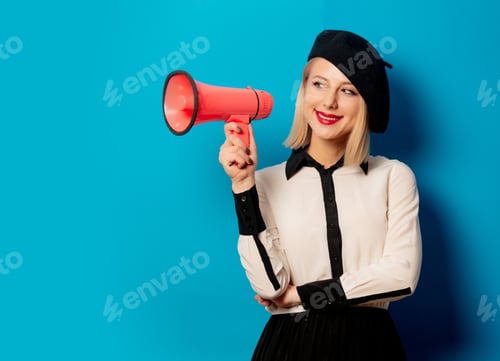 Preview: beautiful french woman in beret holds loud-hailer on blue background