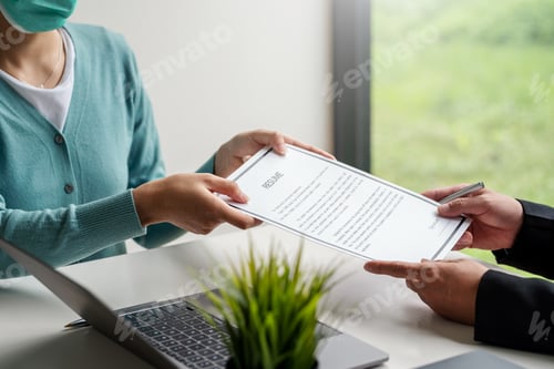 Preview: Woman job applicant submit an application to an employer to read a resume at the office.