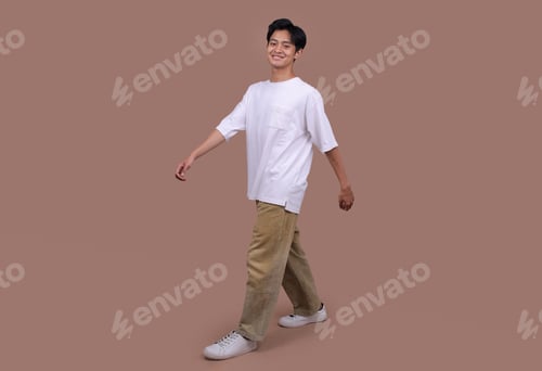Preview: Full Length Smiling Man Walking Toward Wearing White T-shirt Isolated on Beige Background