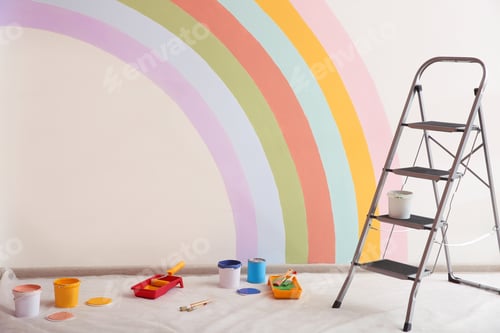 Preview: Different decorator's tools and ladder near wall with painted rainbow indoors