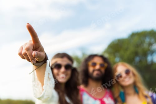 Preview: happy hippie woman pointing finger outdoors
