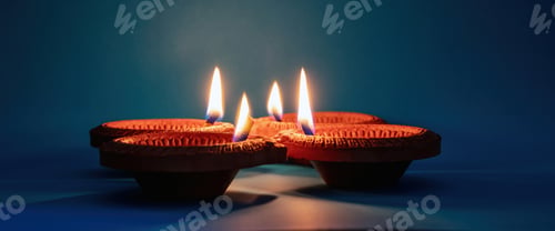 Preview: Diwali, Deepavali Hindu festival of lights. Diya lamp lit on blue background