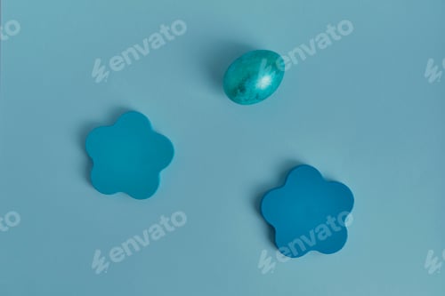 Preview: Painted blue egg, wooden round objects. Flat lay