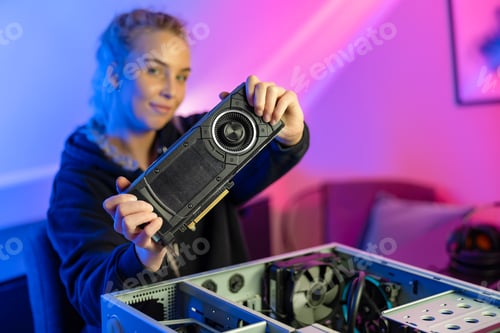 Preview: Blonde Gamer Girl Holding a New GPU Video Card in Her Hands