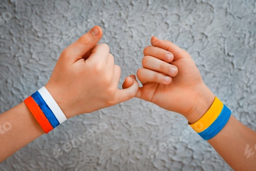 Preview: Reconciliation concept and handshake. Children's Hands with drawing flag of Ukraine and Russia
