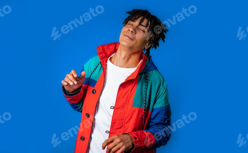 Preview: Energetic african american man dancing, blue background. Stylish guy dreadlocks