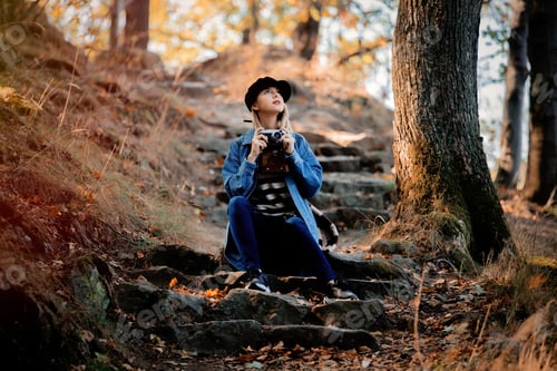Preview: girl with vintage camera have rest in the park in autumn season time