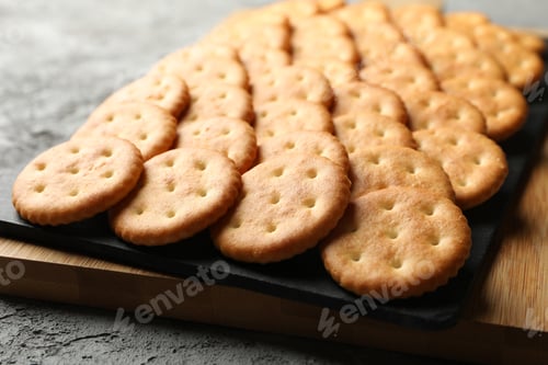 Preview: Board with cracker biscuits on gray background