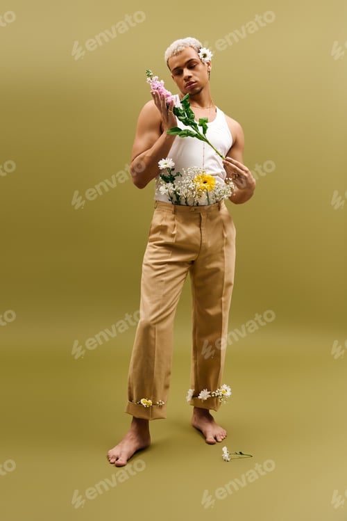 Preview: Young man with dyed hair and flowers showcasing fashion in a vibrant studio setting