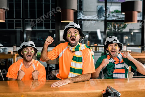 Preview: Football fans watching soccer game and cheering in bar