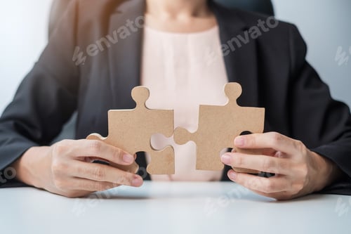 Preview: Woman connecting couple puzzle piece, wood jigsaw on table. Business solutions, mission, success,