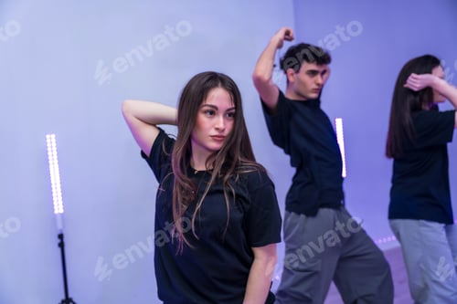 Preview: Young dancers performing modern choreography in dance studio with purple lighting
