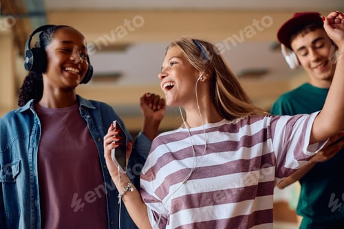 Preview: Cheerful student having fun while listening music at high school.