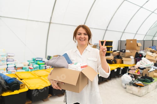 Preview: Volunteer woman preparing donation boxes for people.
