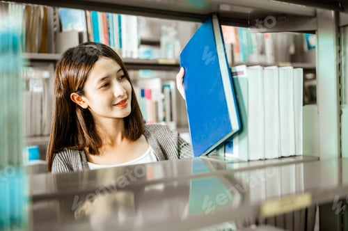 Preview: Asian student college choosing a book for reading before exam at library.Education, Learning, Studen