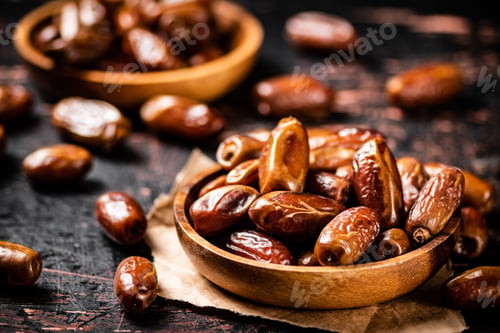 Preview: Delicious dates on a wooden plate.